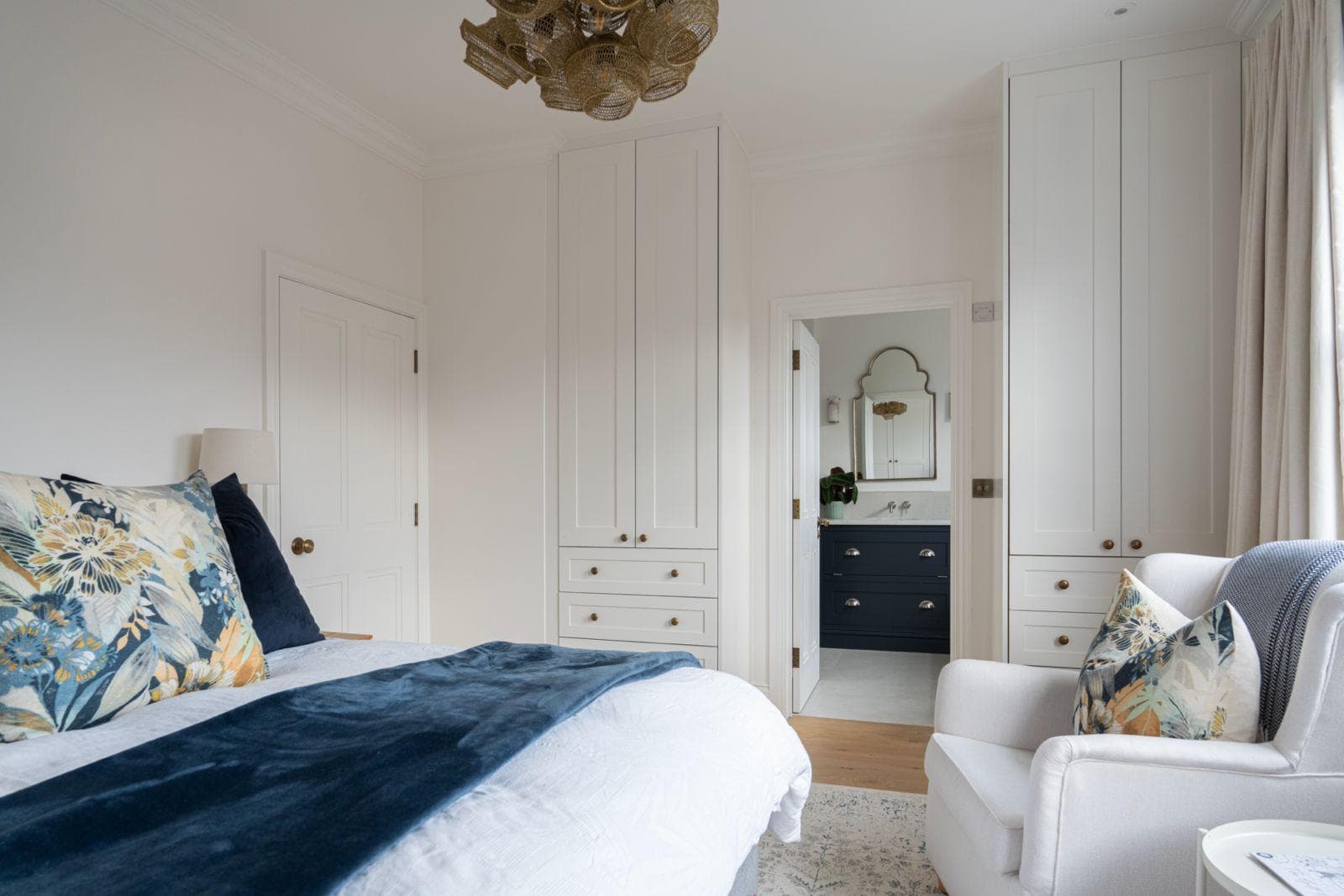 Principal bedroom with bespoke fitted wardrobes flanking a doorway through to the en suite