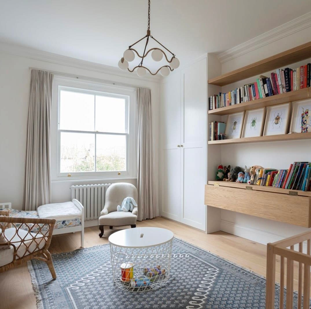 Child's bedroom with built-in oak shelving and a fitted desk, under a glass globe pendant