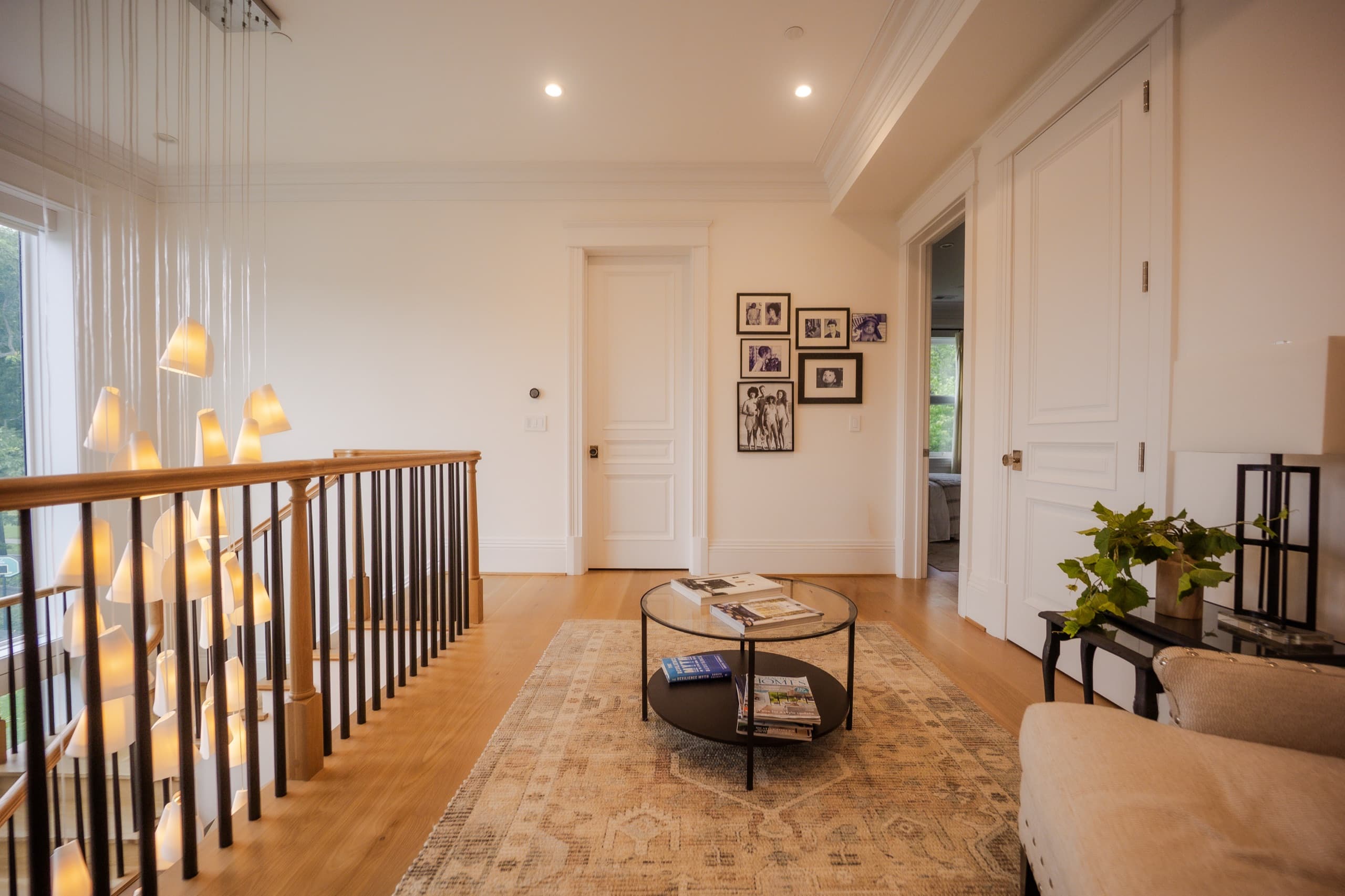 Upper landing with a cascading pendant cluster, gallery wall and an antique runner
