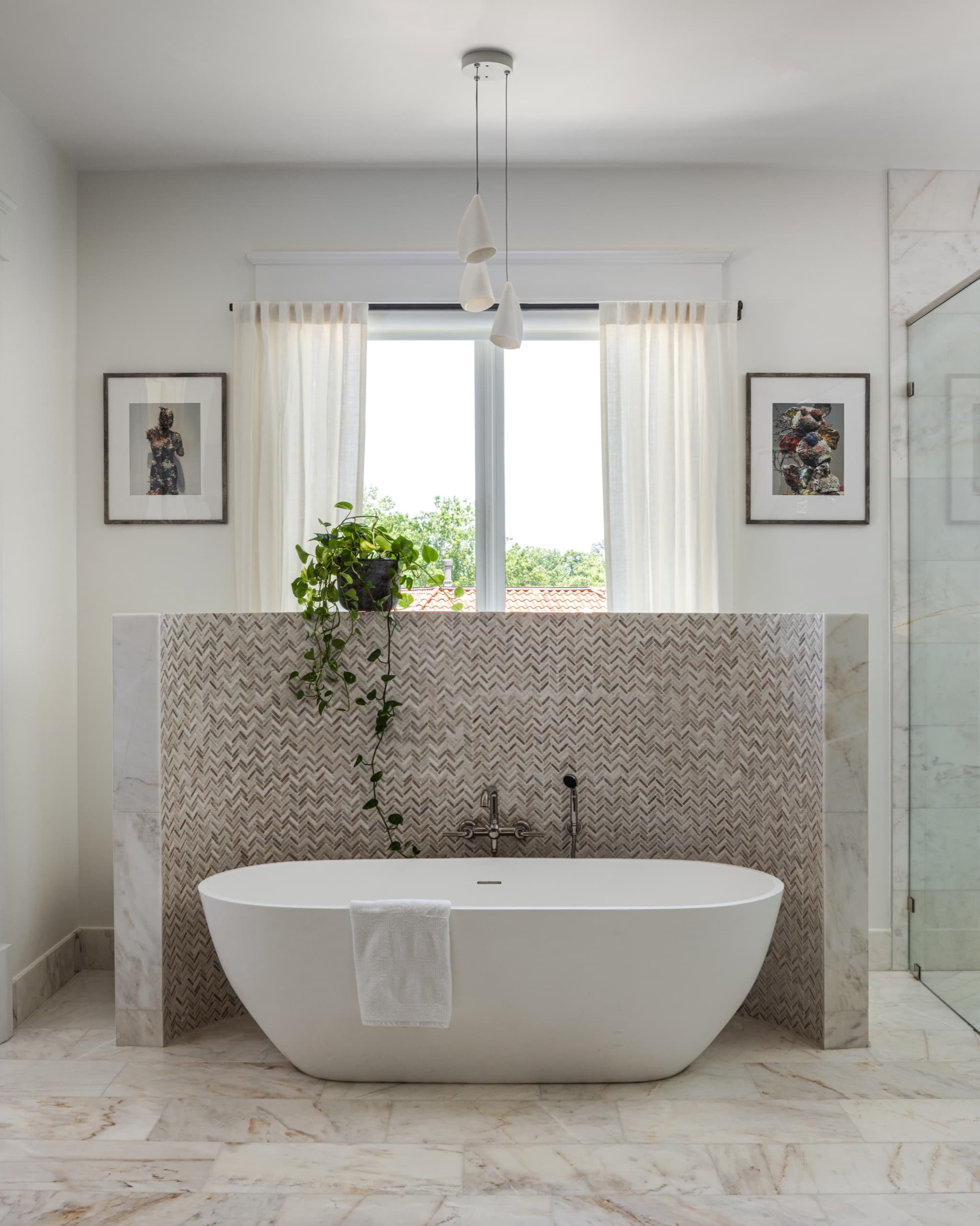 Principal bathroom with a freestanding stone bath set against a herringbone-tiled screen